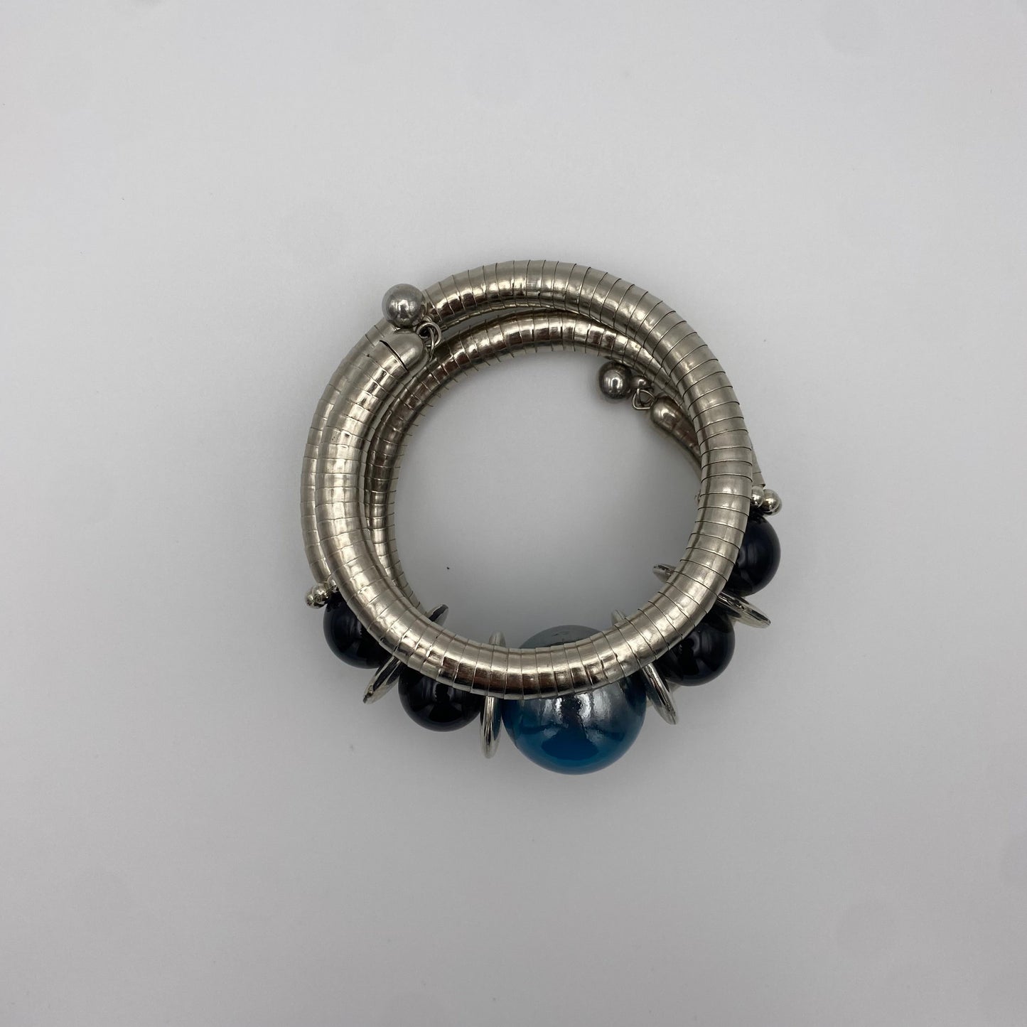 Silberner Spiral-Armreif mit blauen Perlen