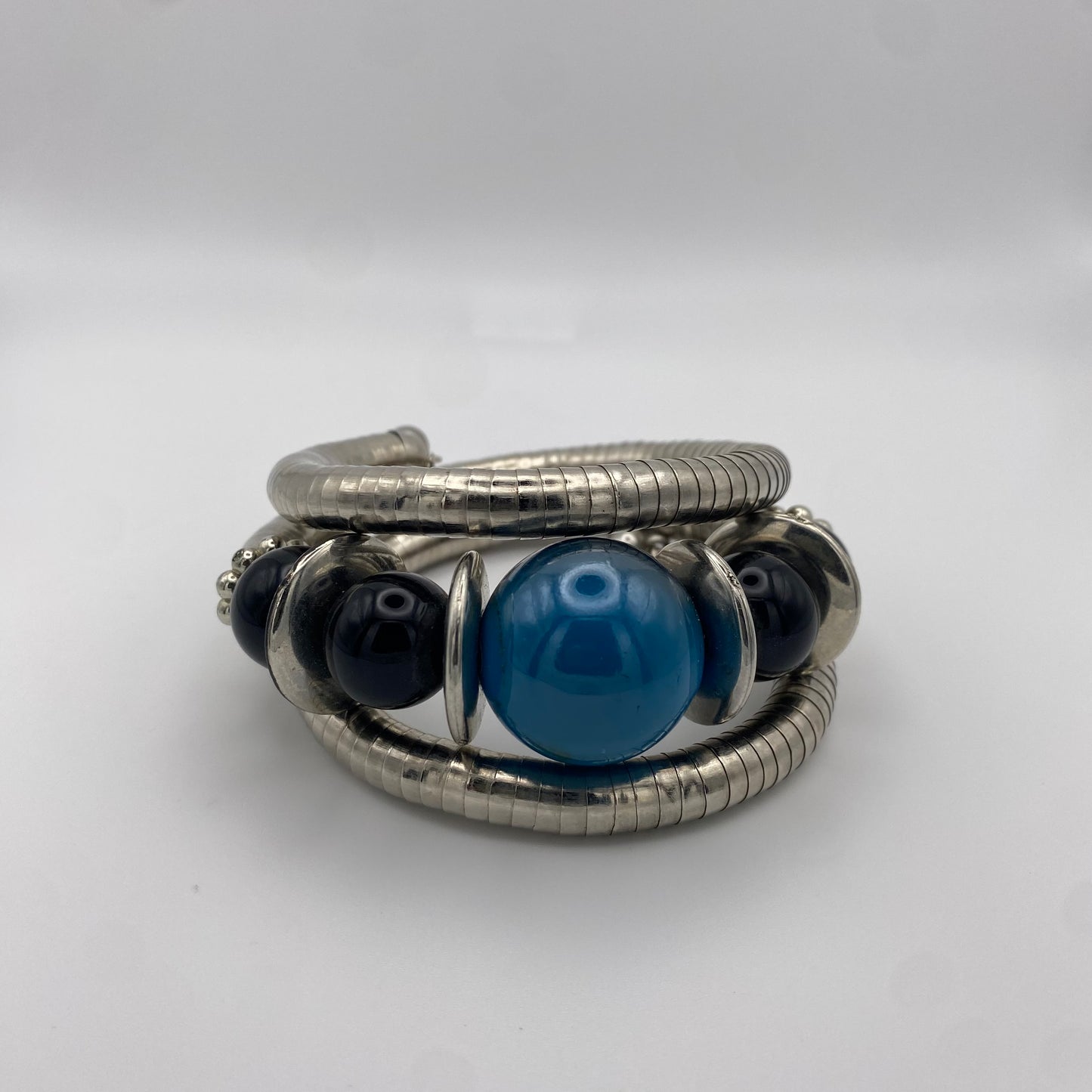 Silberner Spiral-Armreif mit blauen Perlen