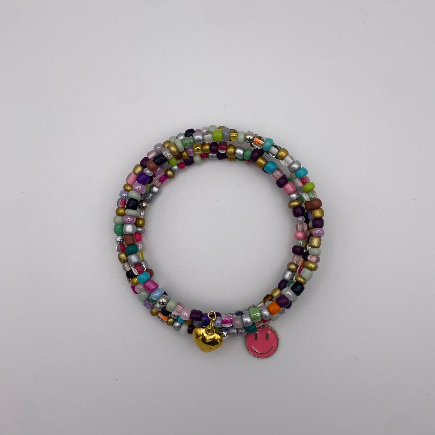 Bunter Spiralarmreif mit pinkem Smiley